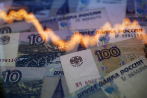 Photo illustration of a reflection of a yearly chart of U.S. dollars and Russian roubles are seen on rouble notes in Warsaw